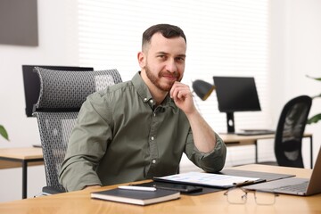 Naklejka premium Handsome man working at desk in office