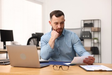 Fototapeta premium Handsome man working at desk in office