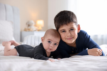 Obraz premium Cute little brothers on bed at home