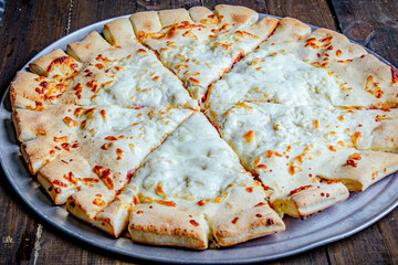 Italian cheese pizza with large cheese slices served in a large pan.