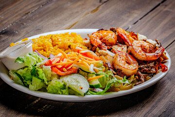 Seafood spicy shrimp and salad dinner in a white plate.