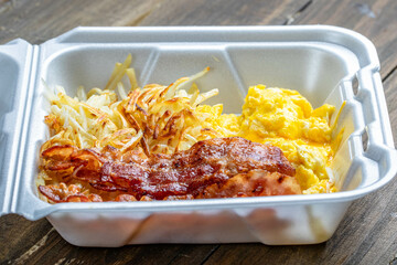 breakfast box with egg and bacon served breakfast with has brown.