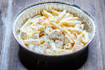 tasty and creamy Italian pasta and chicken with white sauce in a bowl ready for serving.