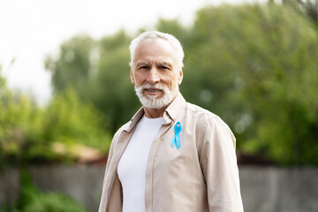 Plakat Senior man wearing light blue ribbon supporting prostate cancer awareness