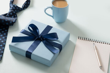 Happy Fathers Day concept. Greeting card with gift, spring-bound notebook on blue background....