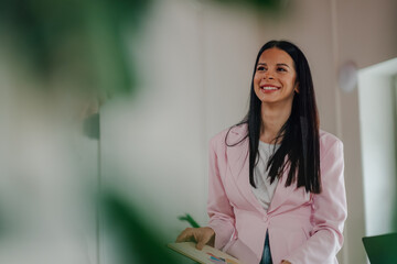 Smiling businesswoman holding charts and presenting successful results