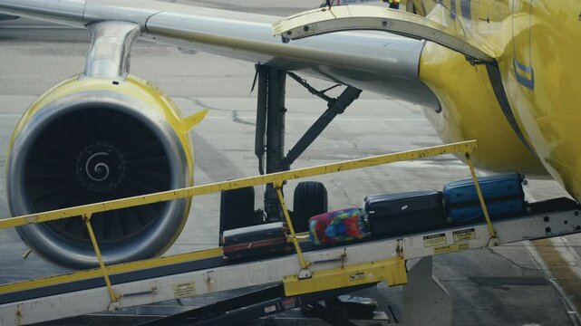 A vibrant image shows a yellow airplane unloading baggage as suitcases cascade down the conveyor belt, highlighting the jet engine and fuselage, capturing the energy of aviation and travel