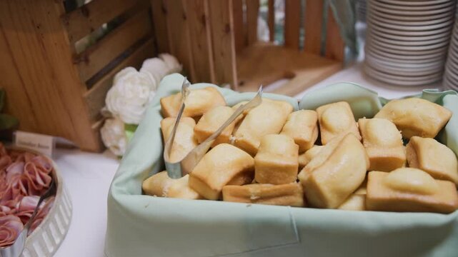Tasty fresh baked cornbread corn bread loafs in slow motion detailed view of appetizer dessert on white decorated table for guests at wedding reception and hosted party event before main dinner