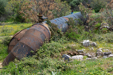 Old big rusty water pipe in a rural area.