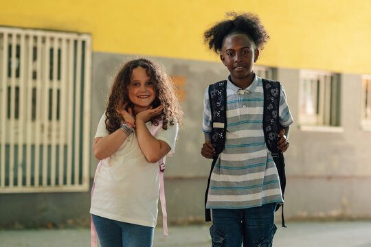 Two elementary school students smiling outside school building