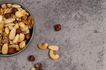 nuts in a bowl.Dry fruits and nuts in bowl with concrete background, mix nuts in a bowl over dark background. Selective focus.