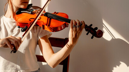 Fototapeta premium Peaceful scene of a woman sitting with her violin in soft daylight