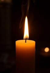 lit candle with a dark background