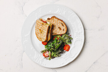 Delicious sandwich and salad on a white plate, ready for a healthy lunch