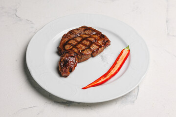 Grilled Steak with Red Chili on a White Plate