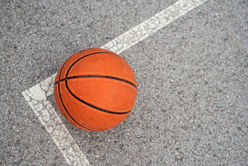 basketball on asphalt court with white line

