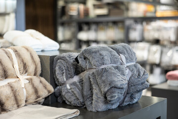 Soft, warm blankets made of various materials and in various colors are also on the shelves of...