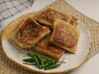 Folded pastry filled with meat filling and fried until golden brown