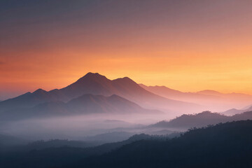 Obraz premium Serene mountain range landscape at sunrise, shrouded in mist under a vibrant orange sky. Evokes tranquility, adventure, and natural beauty. Ideal for travel, wellness, and nature themes.
