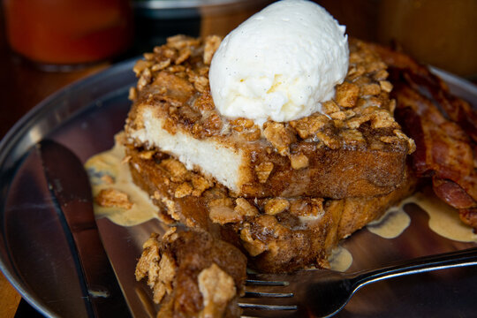 French Toast topped with cereal and whipped cream with a bloody mary and orange juice	