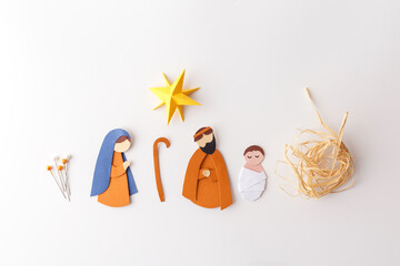 Paper nativity scene parts on brown board with straw, star, baby Jesus and pins. Great for schools,...