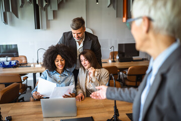 Confident senior businesswoman share documents with colleagues