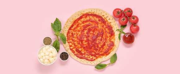 Pizza crust with tomato sauce and ingredients on pink background