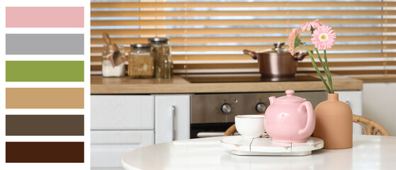 Pink teapot with cup of tea and beautiful flowers on table in kitchen