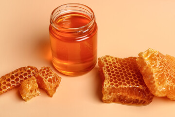 Fototapeta na wymiar Jar with sweet honey and combs on orange background