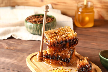 Board with sweet honeycombs on wooden background