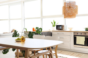 Interior of light kitchen with dining table and counters