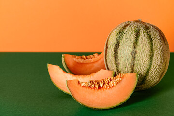 Tasty ripe melon cut slices on color background
