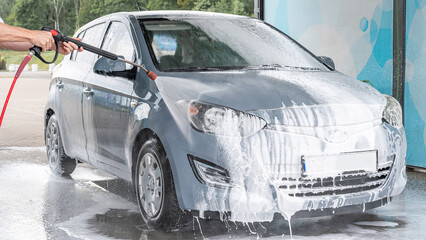 Man cleaning car. Spray hose foam soap. Car wash water shine exterior.