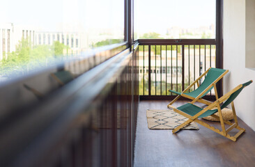 spacious and bright balcony with upholstered chairs, stylish and modern glazing, clear sunny weather