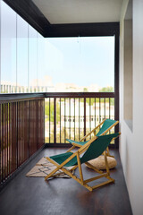 spacious and bright balcony with upholstered chairs, stylish and modern glazing, clear sunny weather