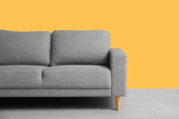 Cozy sofa near orange wall in stylish living room