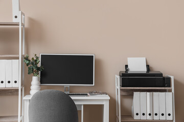 Modern workplace and printer on shelf in office