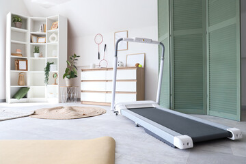 Interior of gym with treadmill, drawers and shelf unit