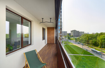spacious and bright balcony with upholstered chairs, stylish and modern glazing, clear sunny weather
