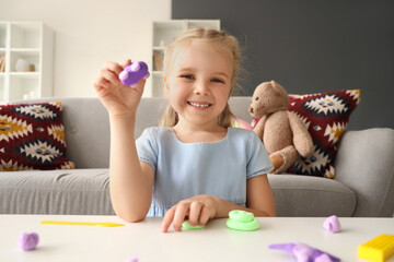 Cute little girl sculpting from plasticine at home
