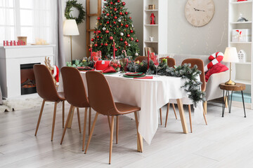 Dining table with setting for Christmas celebration in festive room