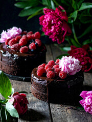 Luxurious chocolate cakes garnished with assorted berries and mint, presented on a contrasting black backdrop.
