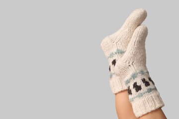 Legs of young woman in knitted socks on grey background