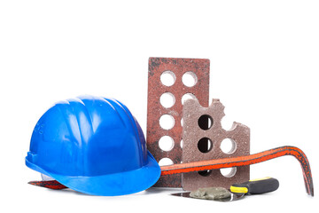 Hardhat, bricks and construction tools on white background