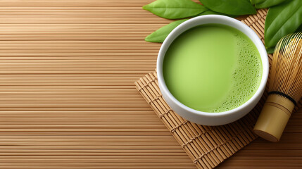Cup of matcha green tea with tea whisk beside it shown from overhead angle. Soft light creates a serene zen aesthetic on bamboo mat. Concept of wellness, tea culture, relaxation