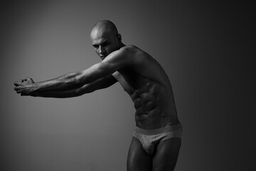 Athletic man posing in a black and white setting, showcasing strength and determination through a...