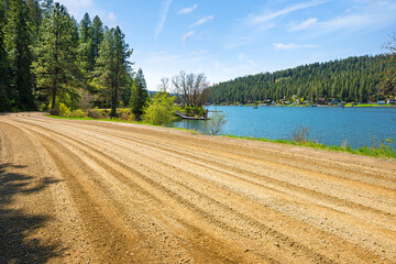 A lakefront gravel and dirt road along Blue Creek Bay, a small inlet of waterfront homes and docks along Lake Coeur d'Alene, in the North Idaho panhandle town of Coeur d'Alene, Idaho.