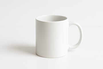 Obraz premium Classic plain white ceramic coffee mug mockup standing on a clean white surface against a white background perfect for showcasing custom designs logos or branding.