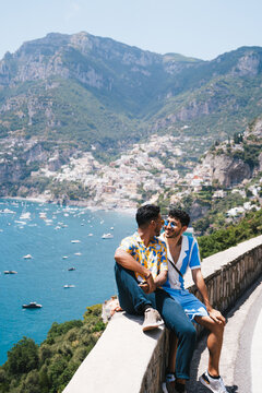 gay couple with red vespa in positano italy enjoying scenic coastal view