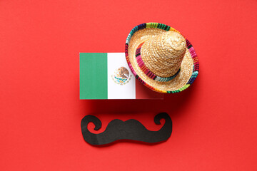 Mexican flag, small sombrero and paper mustache on red background